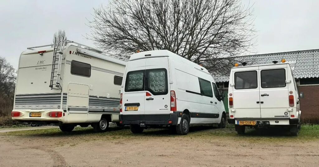 three conversion vans parked side by side during van build