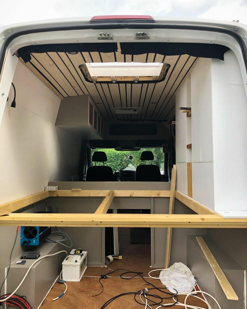 partially completed van build conversion with bed frame installed