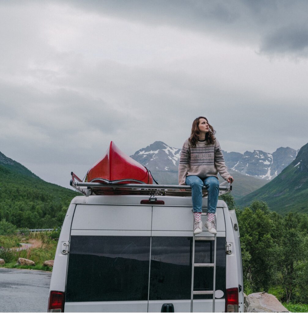 gal sits on top of 4x4 camper van