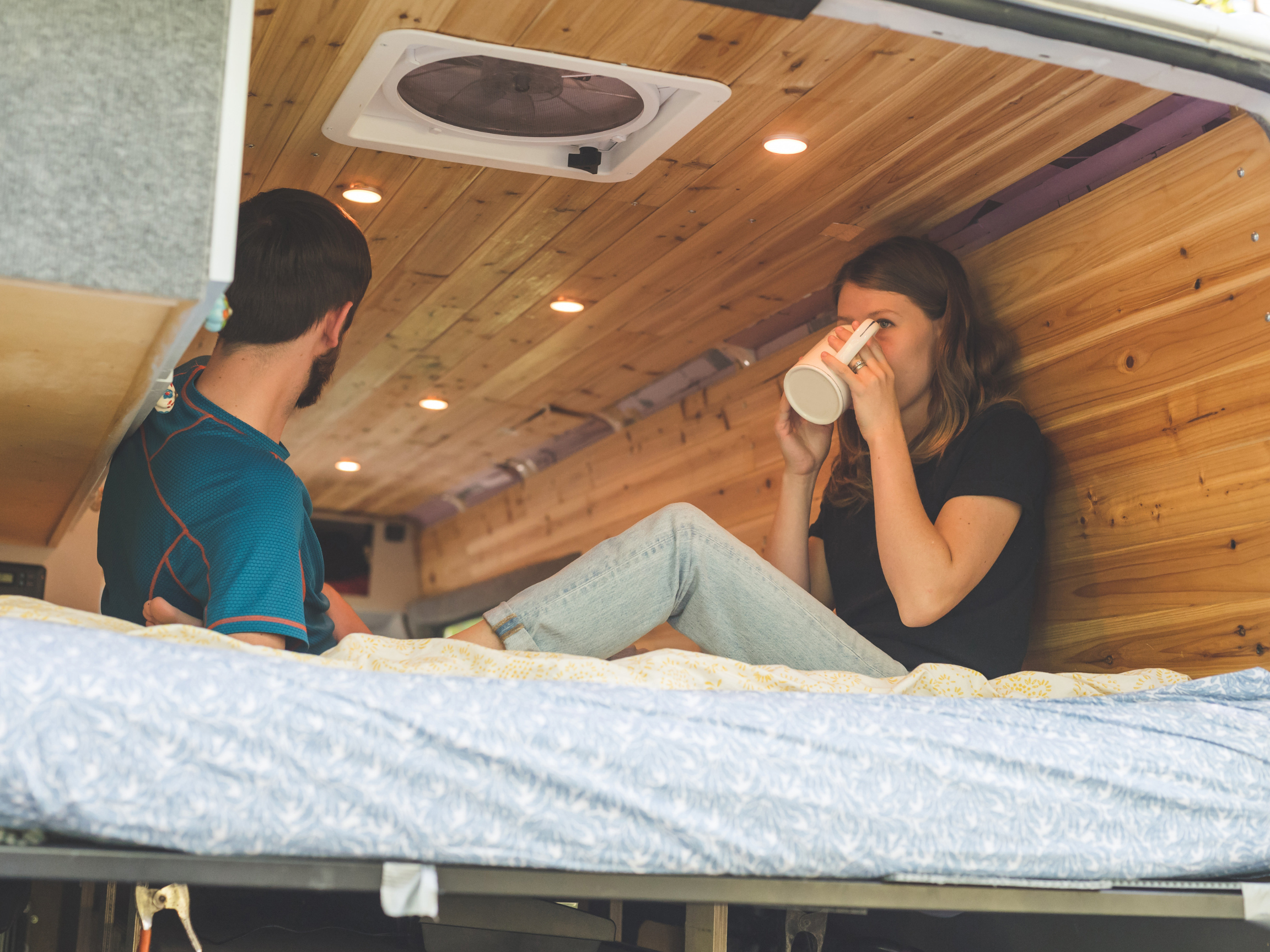 couple enjoys coffee in back of travel van