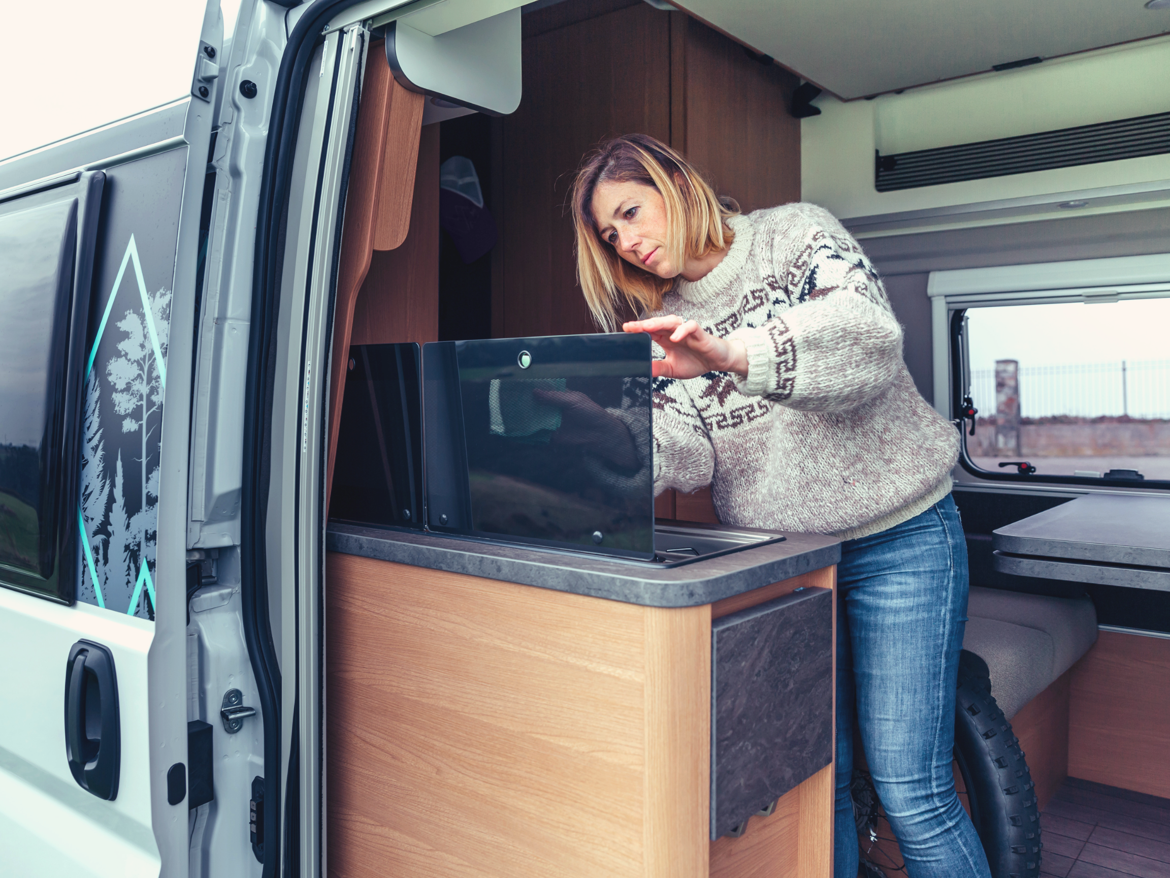 woman with storage compartments in camper van