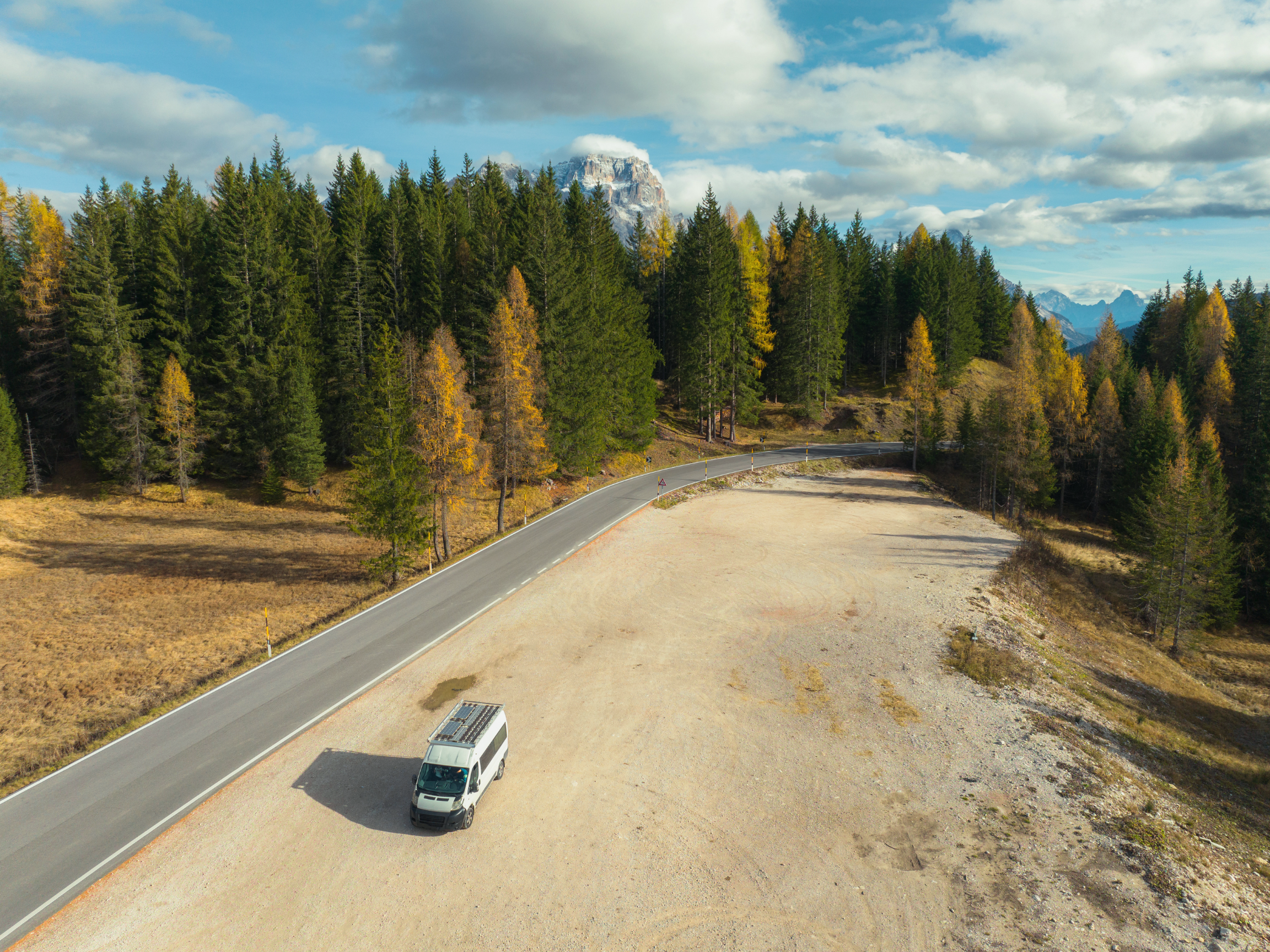 Camper van next to a road in the woods