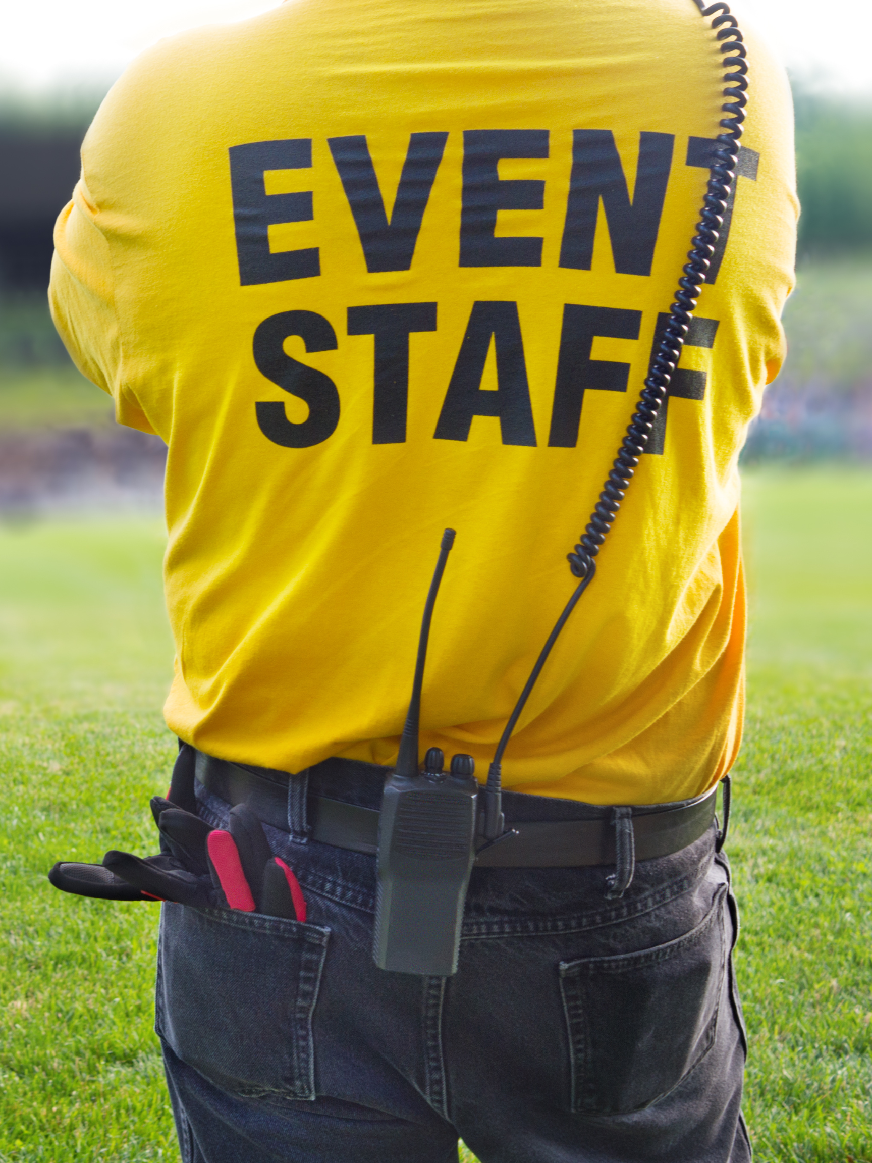 Person with event staff shirt and walkie talkie at event job