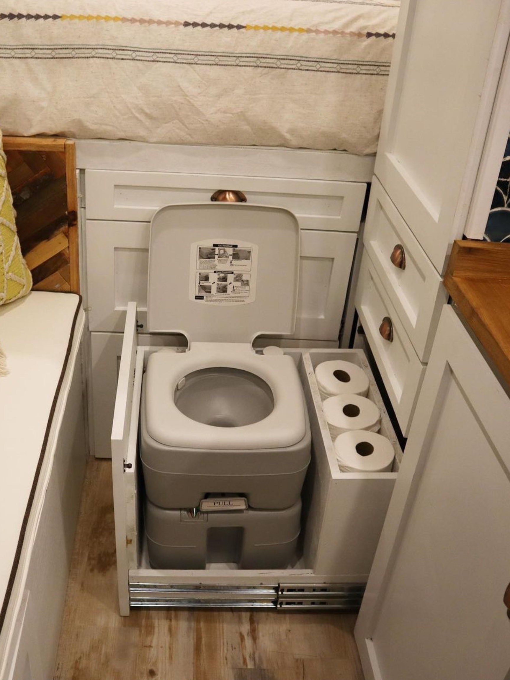 Slide-out toilet in a camper van bathroom