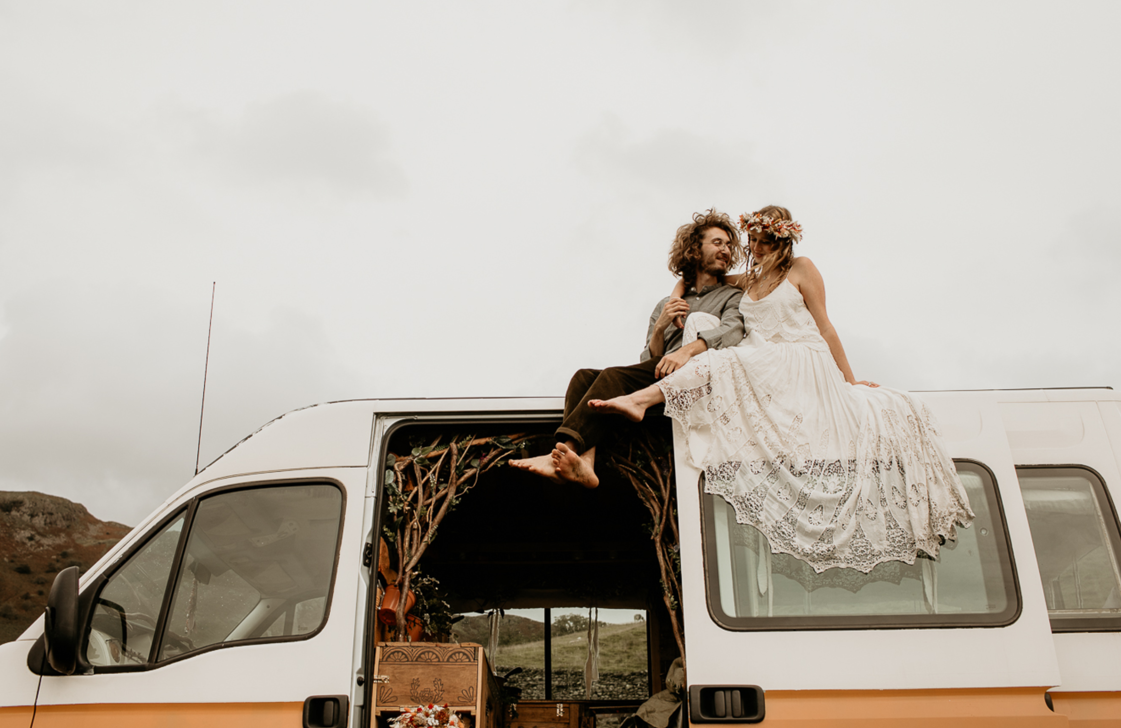 Couple on honeymoon on top of campervan