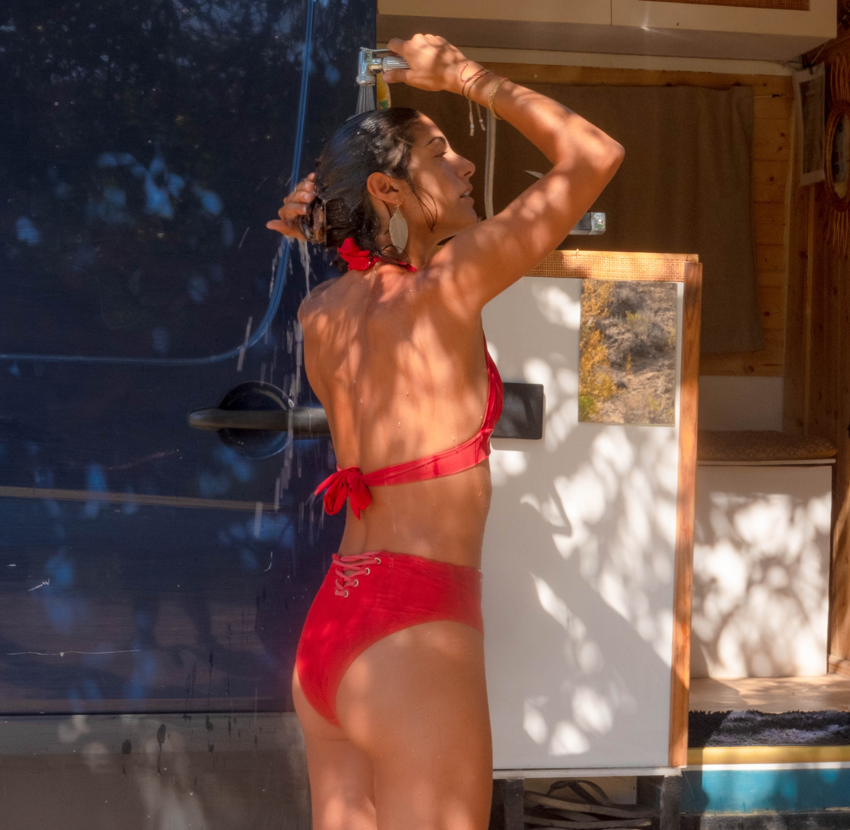 Person taking a shower from a camper van sink