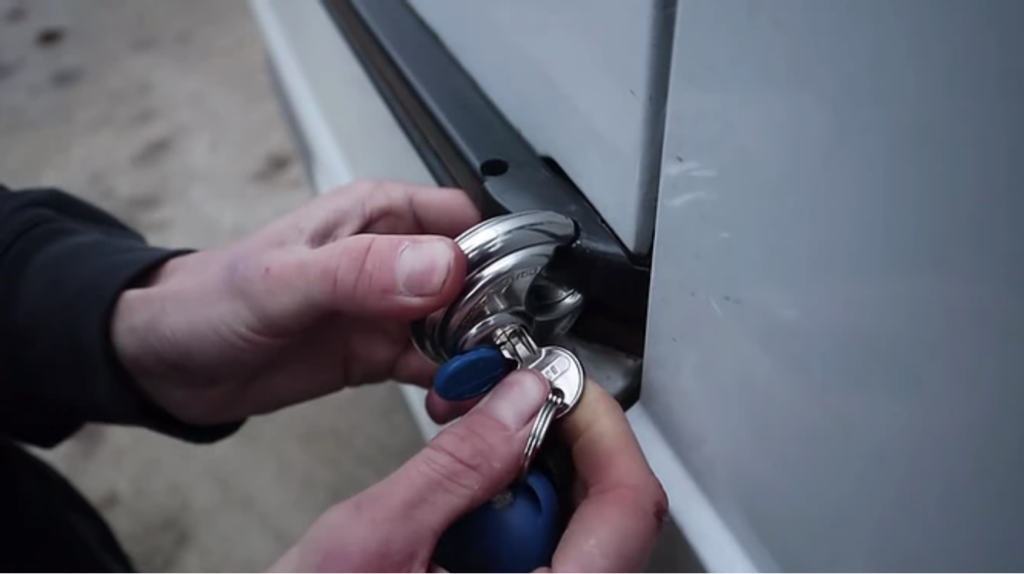 Person locking security padlock on camper van