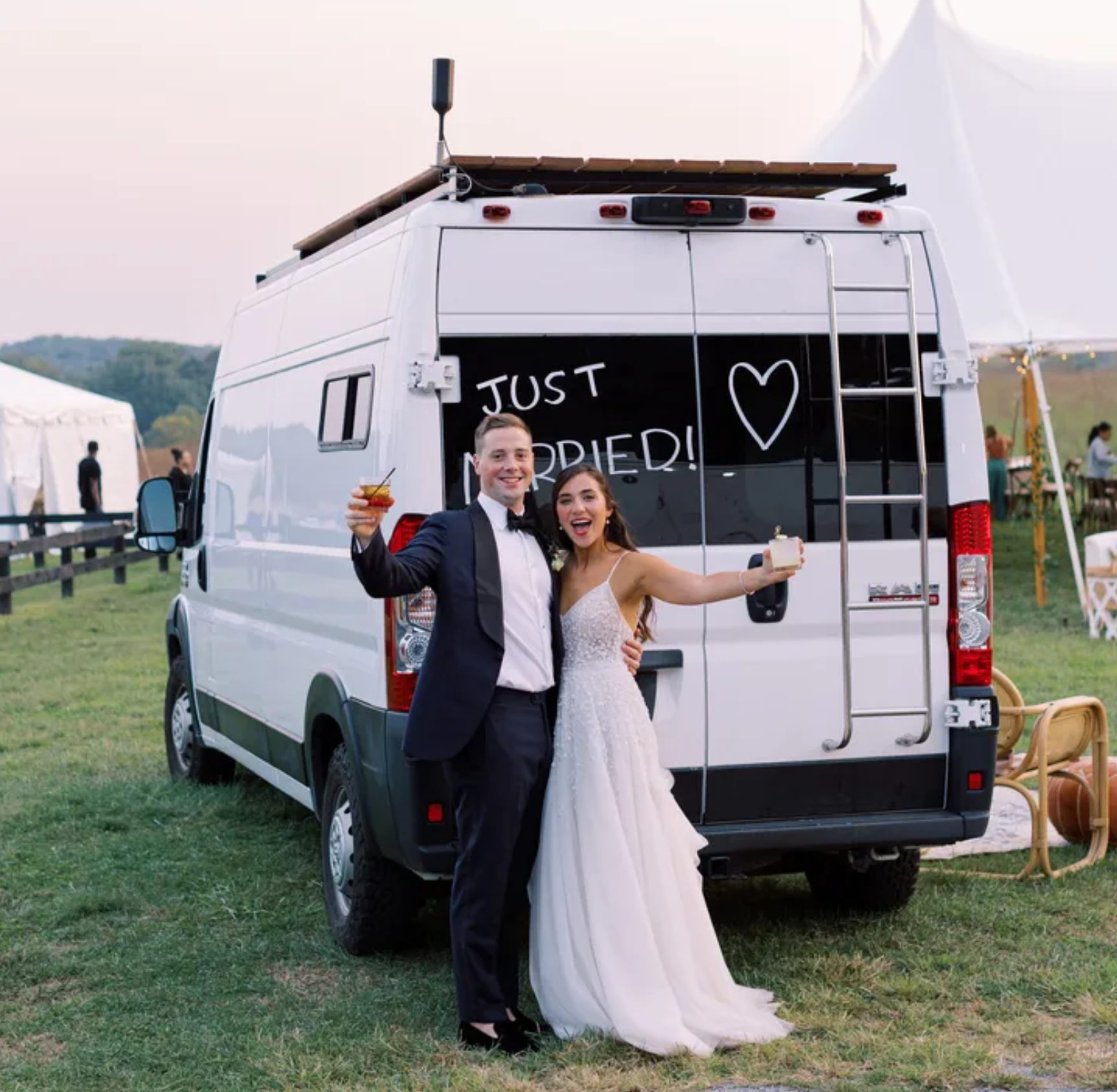 Couple on honeymoon by campervan that says "just married"