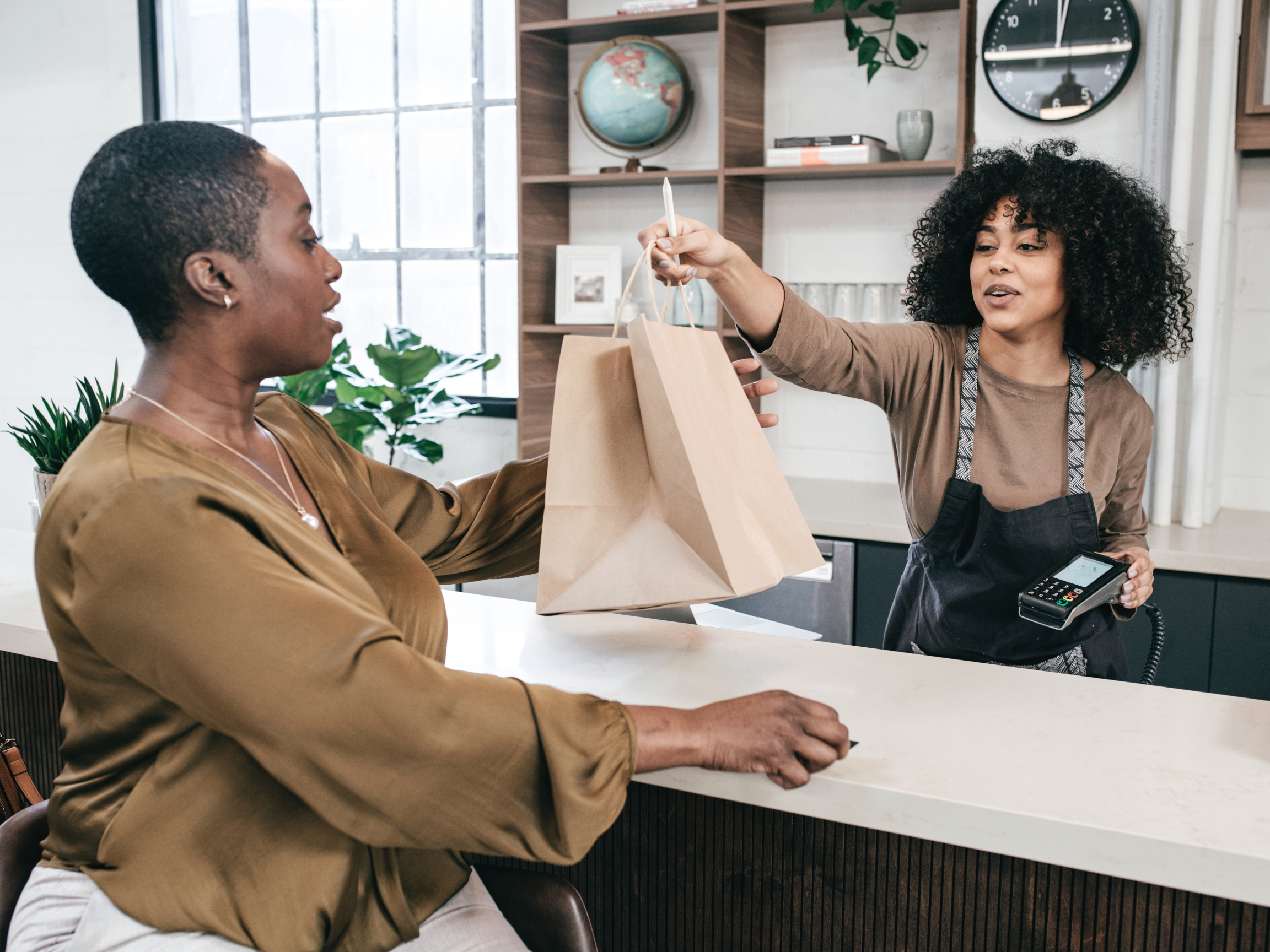 Person at retail job helping customer at register