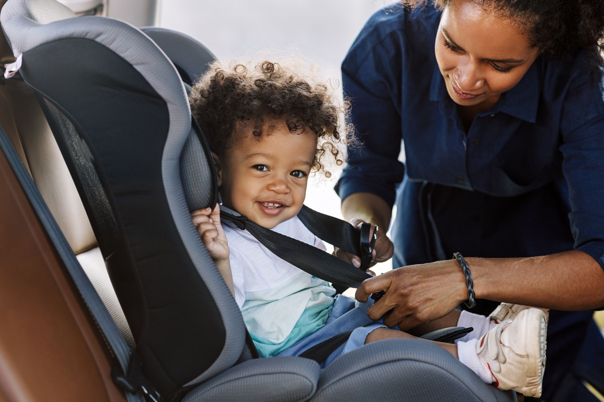 Person strapping child into car seat