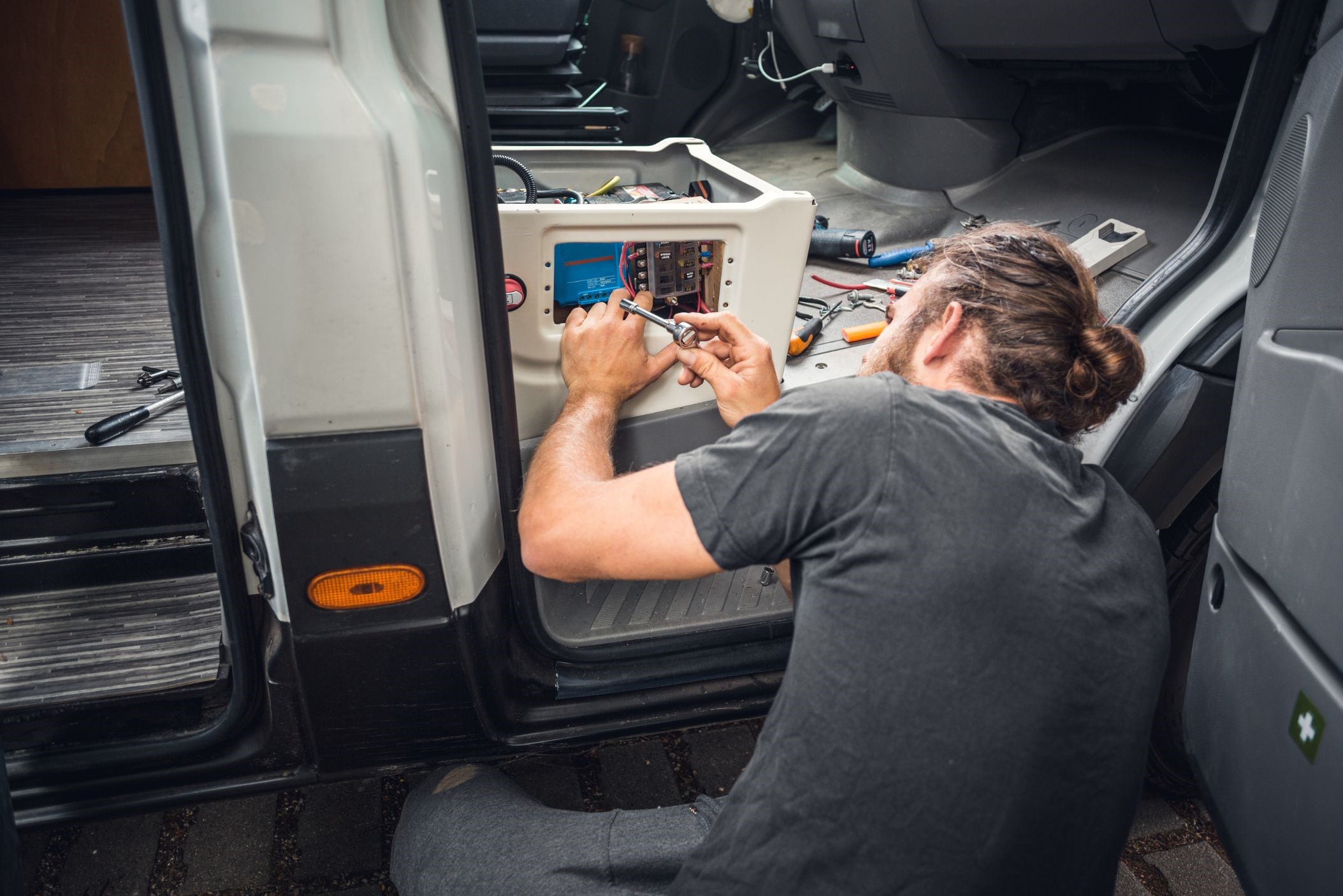 Person installing electrical parts in camper van