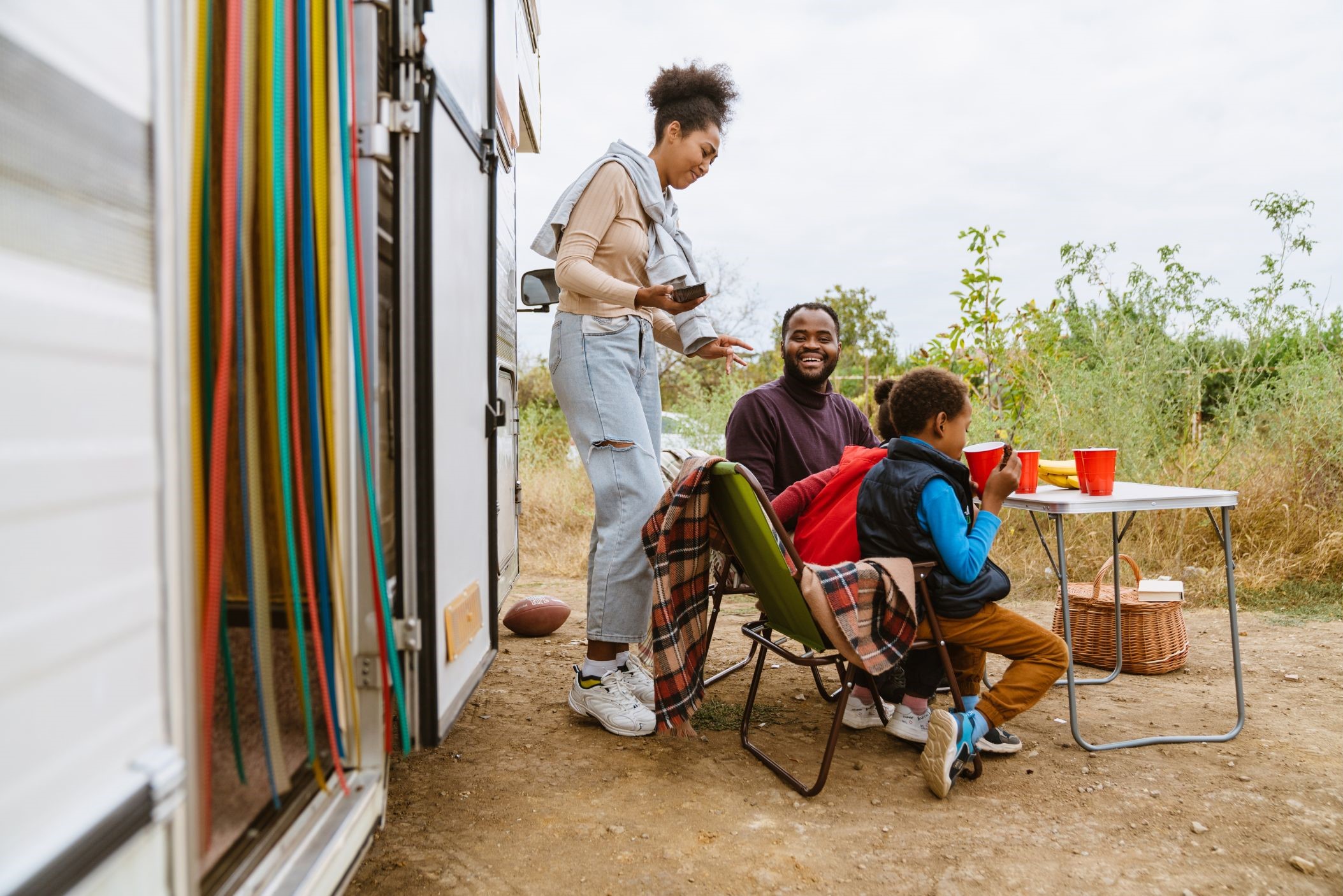 Family sitting at a table outside camper van