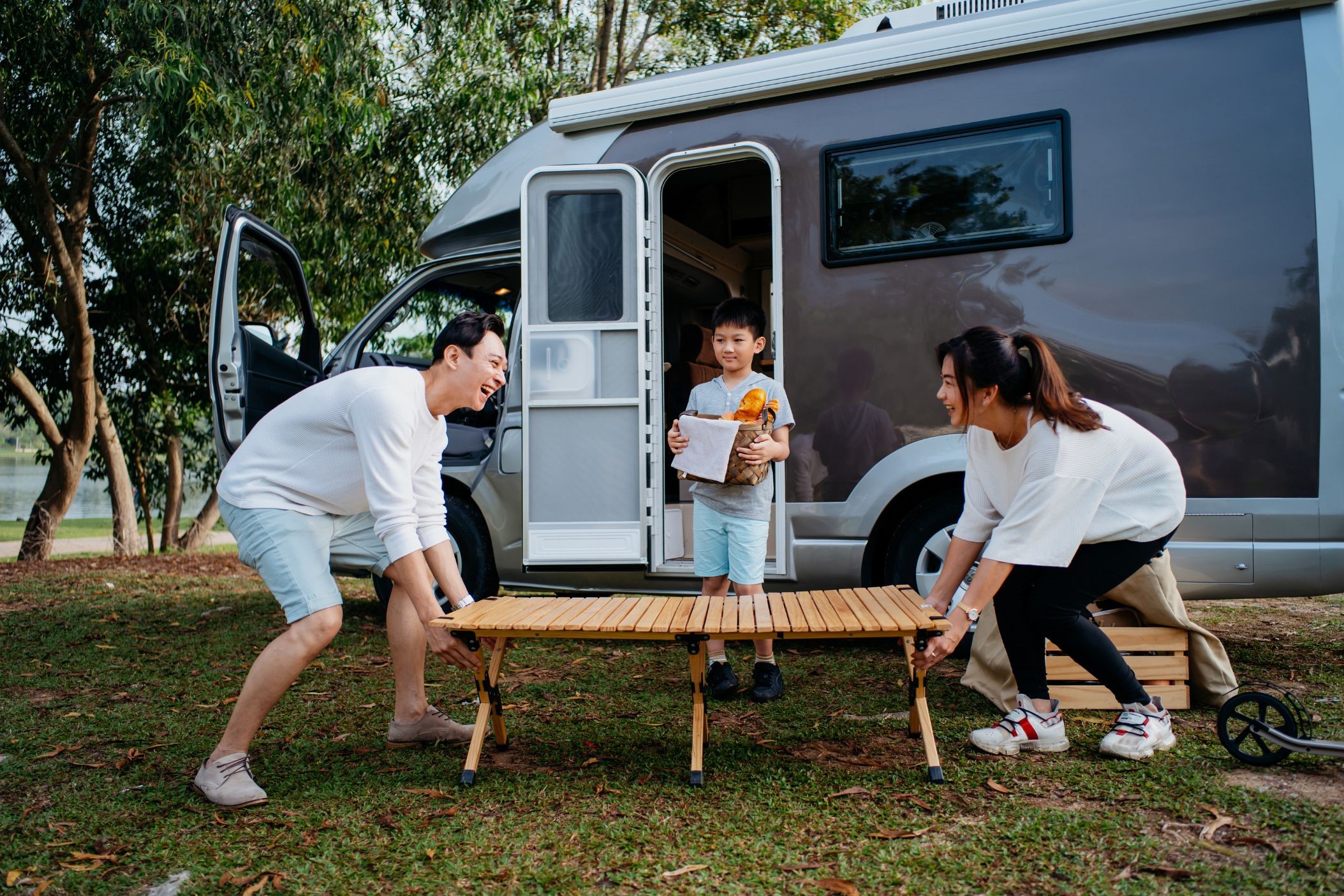 Family setting up table outside camper van