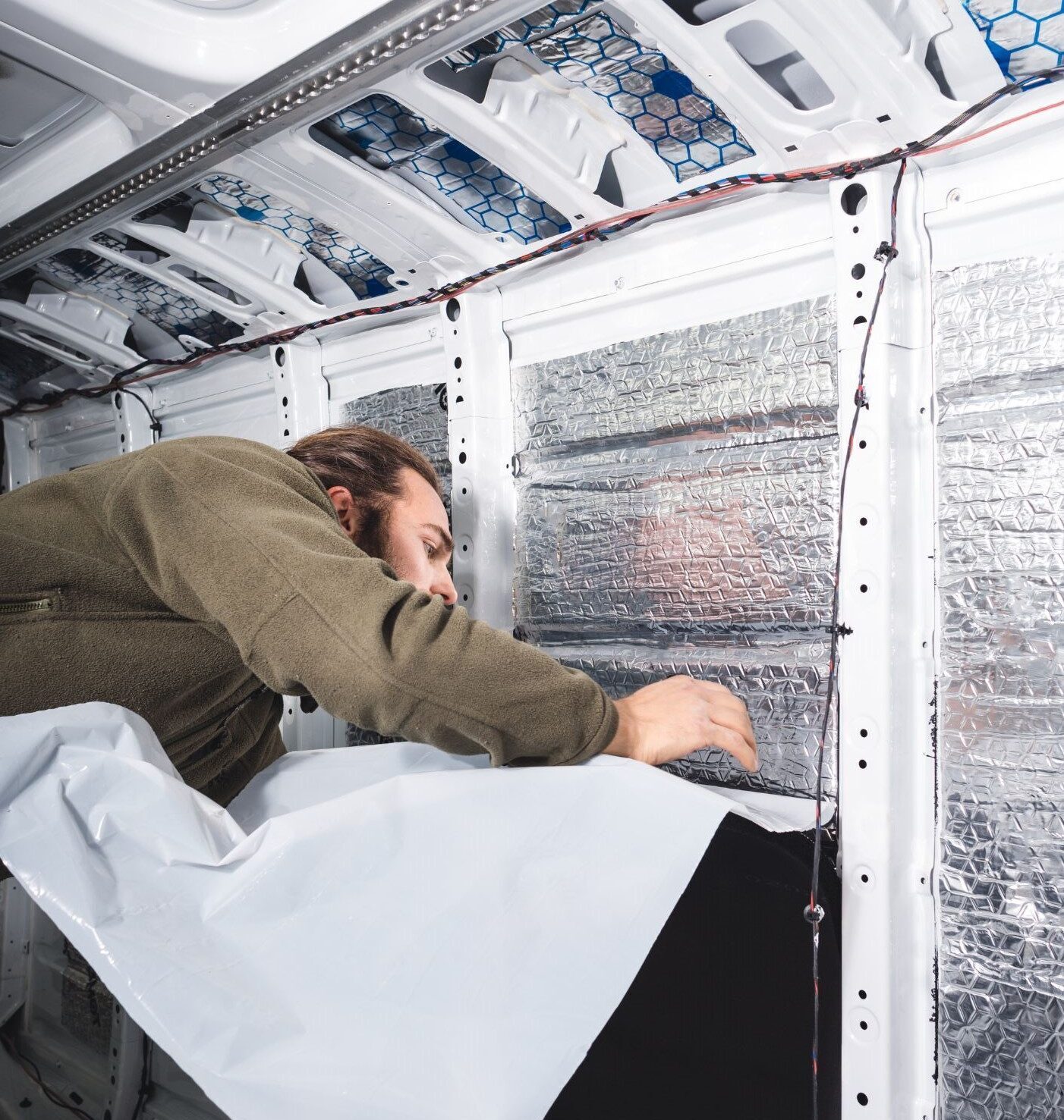 Person installing insulation in campervan